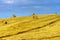 Beautiful yellow hill with haystacks at sunset