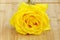 A beautiful yellow rose on wooden base