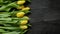 Beautiful yellow tulips on black rustic wooden background. Top view