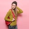 Beautiful young adult student girl with backpack ready to go study. Happy smiling Woman wearing casual outfit posing near pink wal