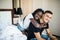 Beautiful young african woman embracing boyfriend from behind in bedroom. Mixed race couple