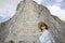 Beautiful young aisan woman is standing and smile on the background of mountain with golden statue of buddha on a hillside, Buddha