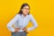 Beautiful young Asian business woman in pain with hands on stomach on yellow background