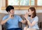 Beautiful young asian couple man and woman gesture high five together while man talking smart mobile phone on sofa
