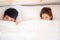 Beautiful young asian couple smiling lovely hiding blanket at bed together, man and woman fun and happy