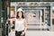 Beautiful young Asian engineer or technician woman smiling, warehouse or factory blur background, industry or logistic concept
