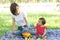 Beautiful young asian mom and daughter playing toy blocks for learning development happy and fun at park in summer