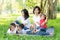 Beautiful young asian parent family portrait picnic in the park, kid or children and mother love happy and cheerful together