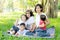 Beautiful young asian parent family portrait picnic in the park, kid or children and mother love happy and cheerful together