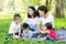 Beautiful young asian parent family portrait picnic in the park, kid or children and mother love happy and cheerful together