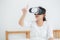 Beautiful young asian woman cheerful and fun wearing vr virtual reality headset, girl device and watching simulator game