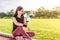 Beautiful young Asian woman exercising in the morning at a running track, taking a rest to drink water