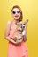 Beautiful young asian woman in nice spring dress, posing in studio with corgi puppy. Fashion photo.