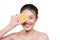 Beautiful young asian woman with orange slices cover her eyes.