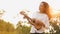 Beautiful young Asian woman playing Ukulele with a smile on her face feeling carefree and happy in the natural autumn sunlight