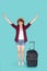 Beautiful young asian woman pulling suitcase isolated on blue background, asia girl having expression cheerful and success