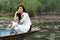 Beautiful young Asian woman in traditional white dress sitting on the boat