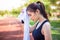 Beautiful young Asian woman wiping off her sweat after her morning exercise at a running track on a brtight sunny morning