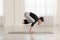 Beautiful young asian woman working out indoors, doing yoga exercise, handstand asana, Crane Crow Pose, Bakasana