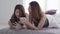 Beautiful young asian women LGBT lesbian happy couple sitting on bed hug and using phone together bedroom at home.