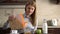 Beautiful young attractive businesswoman pouring cornflakes in a bowl for breakfast in the kitchen.