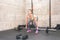 Beautiful young and attractive girl dead lift workout in the gym with small barbell weights as worm up for hard core training