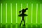 Beautiful young ballerina dancing classical ballet in a dark studio against a background of bright green neon lights