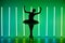 Beautiful young ballerina dancing classical ballet in a dark studio against a background of bright neon lights