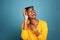 Beautiful young black woman in sunglasses laughing by blue wall