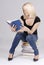 Beautiful young blond student sitting on books