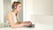 Beautiful young blond telesales woman with headphones on computer talking to customer over the phone