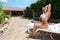 Beautiful young blond woman lying on sunbed in country house area