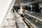 Beautiful young blond woman standing on moving walkways indoor