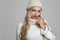 Beautiful young blond woman in white knitted sweater and hat smiling