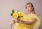 Beautiful young blonde caucasian woman in yellow dress with yellow roses. t