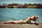 Beautiful young blonde female sunbathing with cell phone in her hands