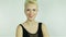 Beautiful young blonde girl with short hair wearing a black dress with bare shoulders smiling expresses emotions joy tenderne