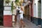 Beautiful young blonde girl from USA sightseeing in Seville, Spain. The girl dressed in a short white skirt and white top strolls