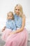 Beautiful young blonde mom and her charming daughter in the same romantic clothes. Happy motherhood. Mother`s day