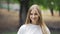 Beautiful young blonde posing against the backdrop of a tranquil park atmosphere. Walk in the park, picnic. Happiness