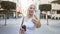 Beautiful young blonde woman confidently smiling as she enjoys her takeaway coffee on a sunlit city street while having a positive