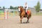 Beautiful young blonde woman riding chestnut horse