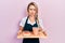 Beautiful young blonde woman wearing waitress apron holding breakfast tray skeptic and nervous, frowning upset because of problem
