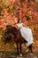 A beautiful young bride sits astride a horse. Autumn Forest
