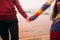 Beautiful young bright happy couple in love holding hands on the berth close up. Sea background