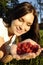 Beautiful young brunet girl holding raspberries