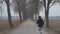 Beautiful young brunette caucasian fitness woman running outdoor at alley in Swedish winter landscape