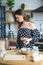 Beautiful young brunette girl in a polka dot dress looks at the kitchen recipe cake dishes