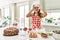 Beautiful young brunette pastry chef woman cooking pastries at the kitchen doing ok gesture like binoculars sticking tongue out,