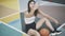 Beautiful young brunette sportswoman taking selfie sitting on basketball court outdoors. Positive confident Caucasian